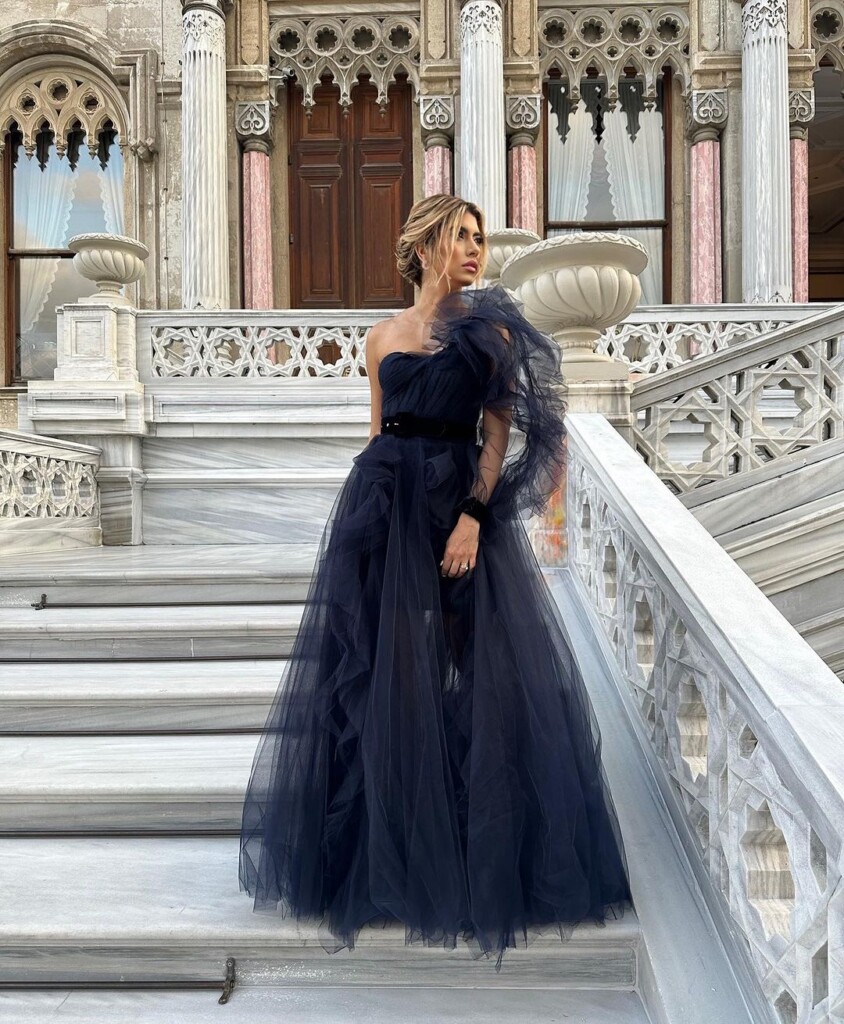 Wedding guest outfit ideas for spring summer lady on the stairs in a wedding guest gown in midnight black 
