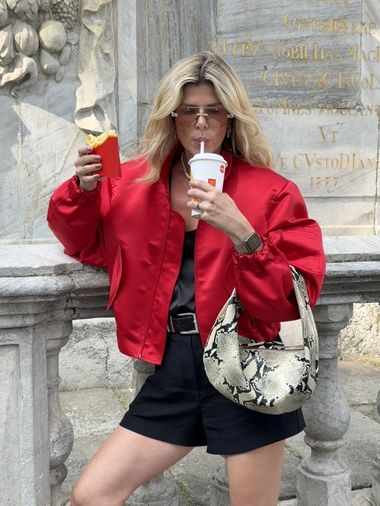 Eva McMahon wearing Meji red bomber with khaite snake print olivia bag,cool autumn outfit idea for women over 40